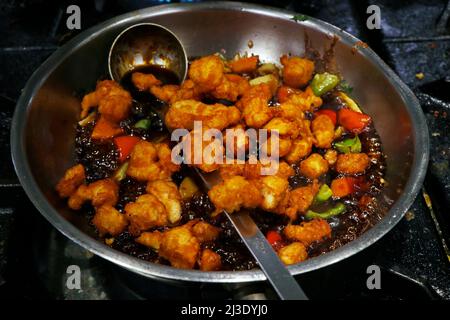 chinesische Zubereitung mit knusprig gebratenem Huhn in einer heißen Pfanne Stockfoto