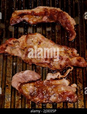 Geräucherter Rind- oder Schweinespeck auf einer heißen Grillplatte Stockfoto