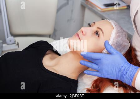 Frau, die eine Ultraschall-Gesichtsmassage auf einem Ultraschallgerät erhält. Stockfoto