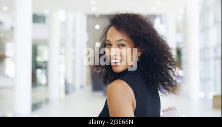 Ihre Konkurrenz hinter sich lassen. Eine kurze Aufnahme einer jungen, schönen Geschäftsfrau in einem modernen Büro. Stockfoto