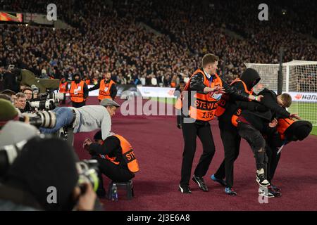 London Stadium, London, Großbritannien. 7. April 2022. Europa League Football West Ham gegen Lyon; Ein wütender West Ham-Fan versucht, einen Eindringling auf dem Spielfeld zu ergattern Credit: Action Plus Sports/Alamy Live News Stockfoto