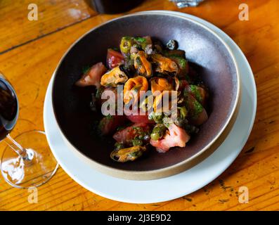 Tomaten mit Pesto, Muscheln, Oliven und Kapern Stockfoto