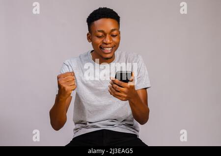 Junger, hübscher Mann über isoliertem Hintergrund, der eine Nachricht oder E-Mail mit dem Handy sendet Stockfoto