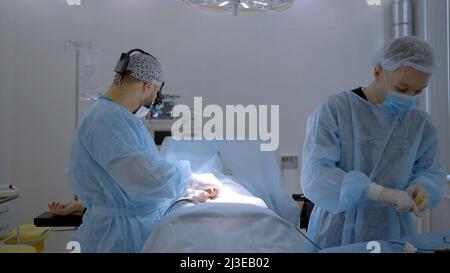 Zwei männliche Chirurgen in einer speziellen Uniform durchführen medizinische Verfahren. Aktion. Konzept von Gesundheit und Medizin. Stockfoto