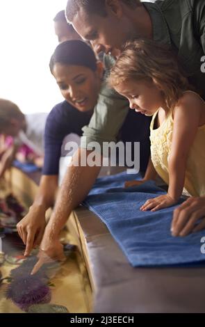 Neugierig, wie sie sich fühlen. Eine Aufnahme einer Familie auf einem Ausflug ins Aquarium. Stockfoto