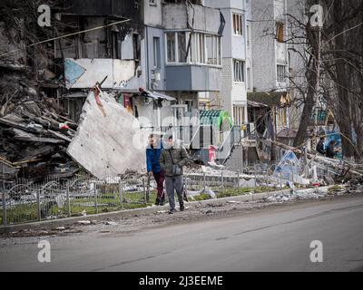 Borodyanka, Ukraine. 06. April 2022. Die Menschen gehen an einem teilweise zerstörten Gebäude vorbei. Nach dem Abzug der russischen Truppe ist das Ausmaß der Zerstörung enorm, und es gibt immer noch Leichen von Menschen, die unter Trümmern begraben sind. Nachdem die Gebäude aufgrund des schweren Beschusses zusammengebrochen waren, erlaubten russische Soldaten den Einheimischen nicht, den Menschen unter den Trümmern zu helfen. Kredit: SOPA Images Limited/Alamy Live Nachrichten Stockfoto