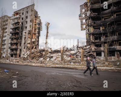 Borodyanka, Ukraine. 06. April 2022. Die Menschen gehen an einem teilweise zerstörten Gebäude vorbei. Nach dem Abzug der russischen Truppe ist das Ausmaß der Zerstörung enorm, und es gibt immer noch Leichen von Menschen, die unter Trümmern begraben sind. Nachdem die Gebäude aufgrund des schweren Beschusses zusammengebrochen waren, erlaubten russische Soldaten den Einheimischen nicht, den Menschen unter den Trümmern zu helfen. (Foto von Jana Cavojska/SOPA Images/Sipa USA) Quelle: SIPA USA/Alamy Live News Stockfoto