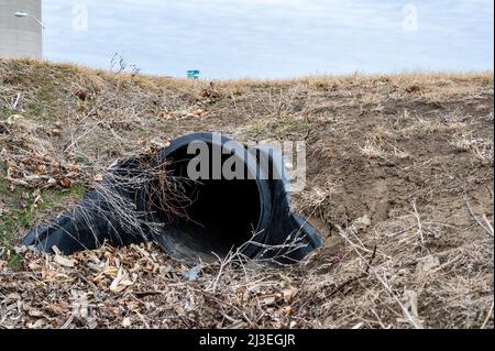 HDPE-Drainage unter einer Straßeneinfahrt. Das Rohr dient zur Förderung von Regenwasser zwischen Gräben. Stockfoto