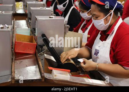 Eine Arbeiterin verpackt in Kediris Zigarettenfabrik „Gudang Garam“ Kretek-Zigaretten. KEDIRI, INDONESIEN – 27. Juni 2019: Stockfoto