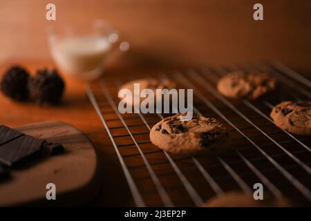Nahaufnahme, frisch gebackene Schokoladenkekse oder Erdnussbutter-Kekse mit Schokoladenstückchen auf einem Kühlregal. Stockfoto