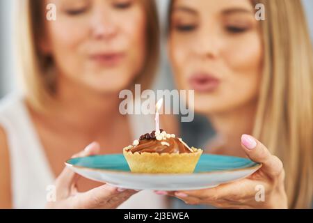 Schöne zwei Erwachsene Mädchen im Haus mit Geburtstagskuchen Stockfoto