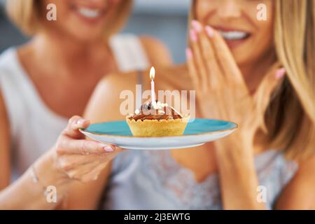 Schöne zwei Erwachsene Mädchen im Haus mit Geburtstagskuchen Stockfoto