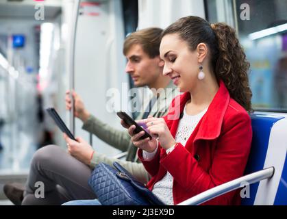 Glückliches Paar beim Lesen von Smartphone und E-Book Stockfoto
