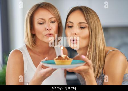 Schöne zwei Erwachsene Mädchen im Haus mit Geburtstagskuchen Stockfoto