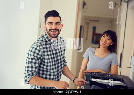 Vergessen Sie den Wasserkühler, der Kopierer ist der Treffpunkt. Porträt eines jungen Geschäftsmannes, der in einem modernen Büro eine Kopiermaschine benutzt. Stockfoto