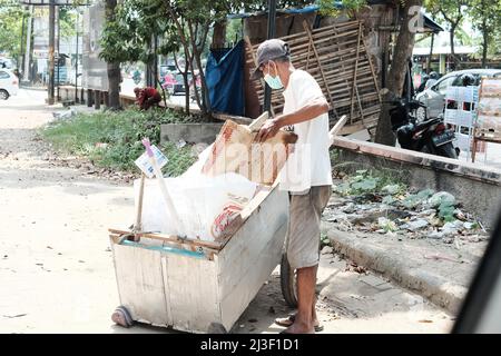 In der Stadt Bandar Lampung benutzt ein Müllsammler einen Wagen. Menschliches Konzept und Sauberkeit in der Stadt Stockfoto