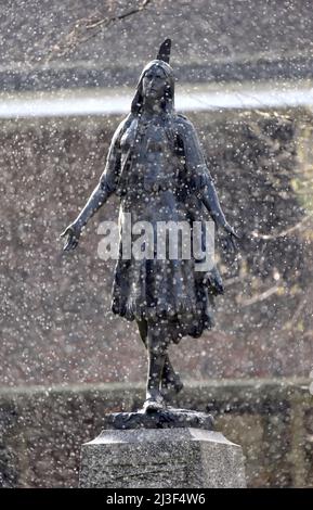 01/04/2022 Gravesend UK Schnee fällt am ersten Apriltag um das Denkmal der Prinzessin Pocahontas auf dem Gelände der St. George’s Church in Grav Stockfoto