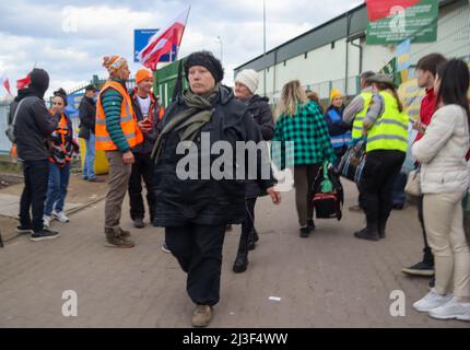 Medyka, Polen. 6. April 2022. Tausende ukrainische Flüchtlinge, die erfolgreich zu Fuß nach Polen einreisen, nachdem sie dem Terror Putins in ihrem Land entkommen sind, betreten das Grenzlager Medyka, wo eine Masse von mitfühlenden internationalen Freiwilligen bereit ist, ihnen bei jedem Schritt auf dem Weg in Sicherheit und in ihre neue Heimat zu helfen. (Bild: © Amy Katz/ZUMA Press Wire) Stockfoto