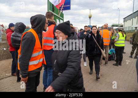 Medyka, Polen. 6. April 2022. Tausende ukrainische Flüchtlinge, die erfolgreich zu Fuß nach Polen einreisen, nachdem sie dem Terror Putins in ihrem Land entkommen sind, betreten das Grenzlager Medyka, wo eine Masse von mitfühlenden internationalen Freiwilligen bereit ist, ihnen bei jedem Schritt auf dem Weg in Sicherheit und in ihre neue Heimat zu helfen. (Bild: © Amy Katz/ZUMA Press Wire) Stockfoto