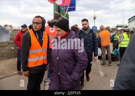 Medyka, Polen. 6. April 2022. Tausende ukrainische Flüchtlinge, die erfolgreich zu Fuß nach Polen einreisen, nachdem sie dem Terror Putins in ihrem Land entkommen sind, betreten das Grenzlager Medyka, wo eine Masse von mitfühlenden internationalen Freiwilligen bereit ist, ihnen bei jedem Schritt auf dem Weg in Sicherheit und in ihre neue Heimat zu helfen. (Bild: © Amy Katz/ZUMA Press Wire) Stockfoto