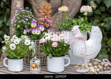 osterdekoration mit rosa und weißen Frühlingsblumen und osterhuhnchen Stockfoto