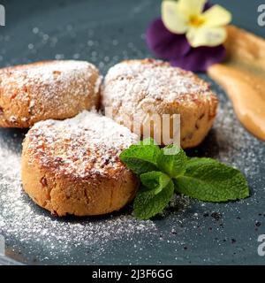 Vegane Pfannkuchen mit Tofu-Käse auf einem blauen Teller und Bananencreme aus der Nähe Stockfoto