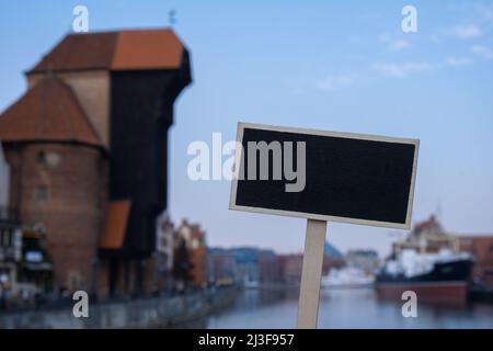 Leere Mockup Vorlage Blackboard Label gegen Danzig schöne Altstadt über Motlawa Fluss. Der Suraw Kranich und bunte gotische Fassaden der alten Stockfoto