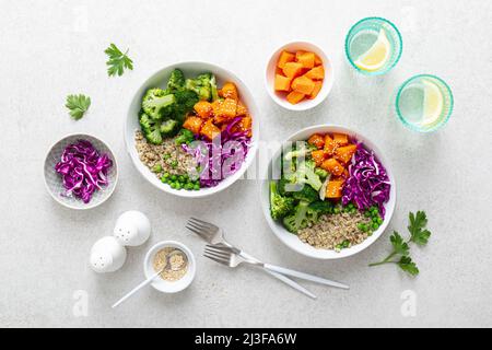 Vegetarische Quinoa und Brokkoli Lunch Buddha Schale mit gebackenem Butternusskürbis oder Kürbis, grünen Erbsen und Rotkohl. Draufsicht Stockfoto