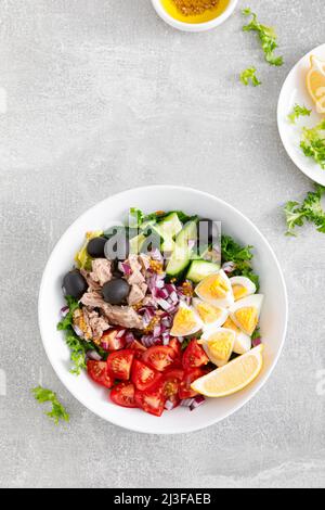 Thunfisch und frischer Gemüsesalat mit Tomaten, Gurken, Oliven, Zwiebeln, Salat und gekochtem Ei, Draufsicht Stockfoto