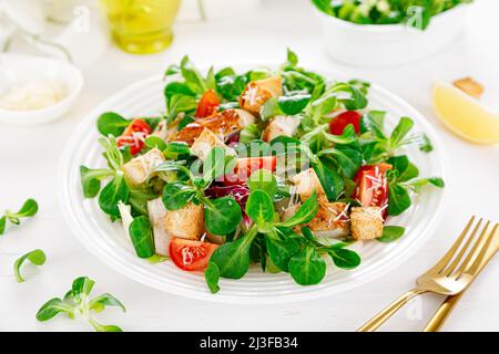 Caesar-Salat mit gegrilltem Hähnchenfleisch, frischen Tomaten, Croutons, Lämmersalat und Parmesankäse. Gesundes Mittagessen. Draufsicht Stockfoto