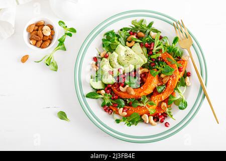 Frischer Gemüsesalat mit Lammsalat, gebackenem Butternusskürbis oder Kürbis, Avocado, Granatapfel, Cashew und Mandelnüssen Stockfoto