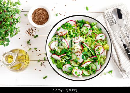 Rettich- und Gurkensalat mit Salat und frischen grünen Zwiebeln. Draufsicht Stockfoto