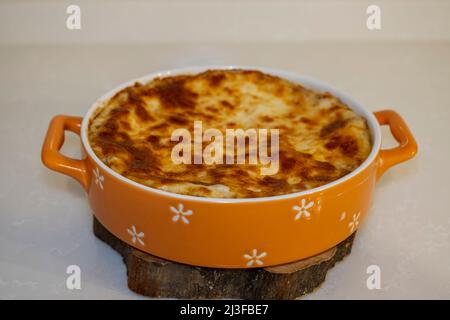 Traditionelle italienische Lasagne mit Hackfleisch und geschmolzenem Käse. Gebacken in einer runden Backform. Isoliert. Selective Focus Dish Stockfoto