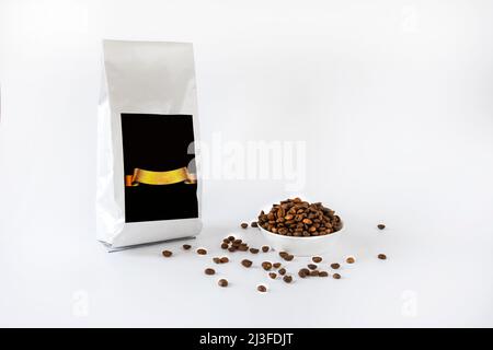 Kaffeebohnen und Kaffeepaket auf weißem Hintergrund Stockfoto