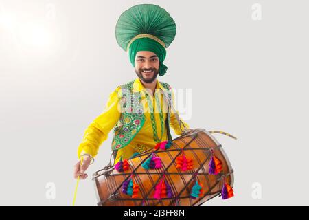 Portrait des Sikh-Mannes, der während der Baisakhi-Feier Trommel spielt Stockfoto