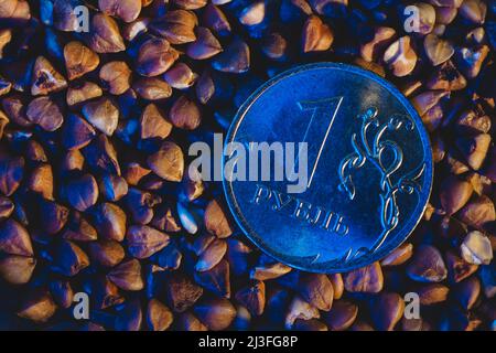Eine Rubel-Münze in Buchweizen unter blauem Licht Stockfoto