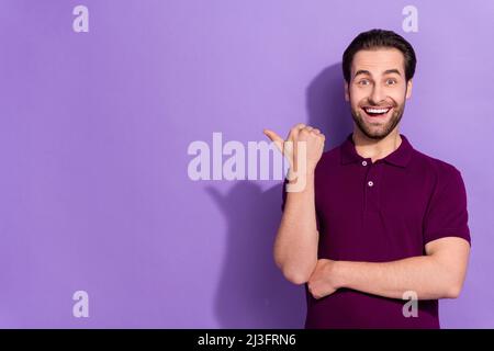 Foto von beeindruckt Millennial Brunet guy Index Förderung tragen lila T-Shirt isoliert auf violetten Hintergrund Stockfoto