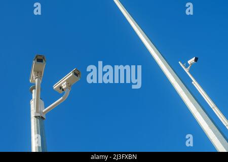 Geschlossene Fernsehkameras, isoliert gegen einen klaren blauen Himmel Stockfoto