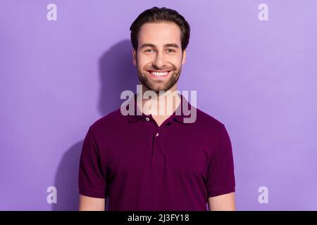 Foto von Horay Millennial Brunet Kerl tragen lila T-Shirt isoliert auf violetten Hintergrund Stockfoto