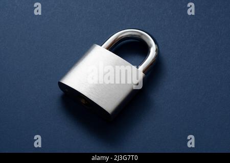 Verriegeltes Vorhängeschloss auf blauem Hintergrund. Stockfoto