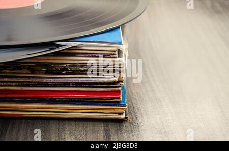 Stapel alter Vinylscheiben auf Holzhintergrund Stockfoto