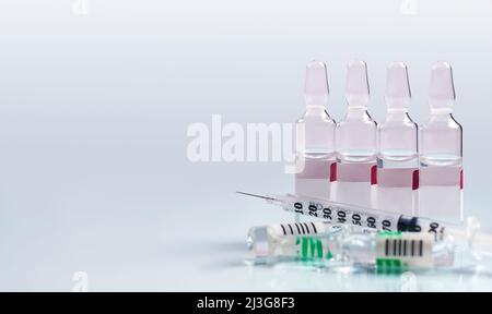 Medizinische Spritze und Medikamente zur Injektion auf weißem Hintergrund Stockfoto