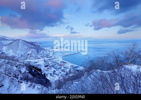 Im Winter ist der Sonnenaufgang im Hafen von Rausu am Morgen. Schöne Winterlandschaft aus Japan. Schnee in der Stadt Rausu, Ende der Nacht. Rausu ist eine Stadt in Men Stockfoto