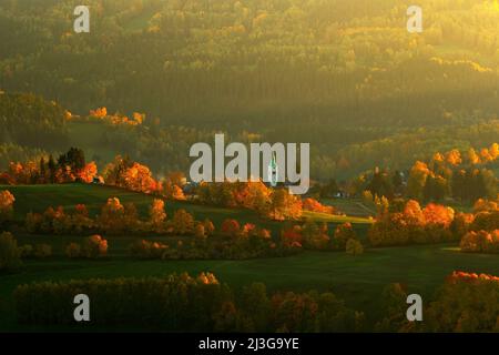 Abend in der Kasperske Hory Kirche, Sumava, Tschechische Republik. Kalter Tag im Sumava Nationalpark, Hügel und Dörfer in Orangenbäumen, nebliger Blick auf czech la Stockfoto