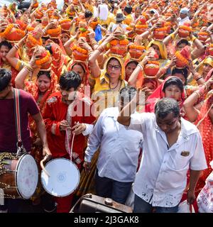 Neu Delhi, Indien April 03 2022 - Frauen mit Kalash am Kopf während des Jagannath-Tempels Mangal Kalash Yatra tragen indische Hindu-Anhänger irdische Töpfe Conta Stockfoto