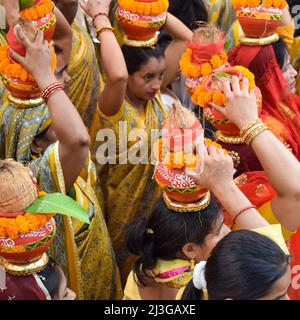 Neu Delhi, Indien April 03 2022 - Frauen mit Kalash am Kopf während des Jagannath-Tempels Mangal Kalash Yatra tragen indische Hindu-Anhänger irdische Töpfe Conta Stockfoto