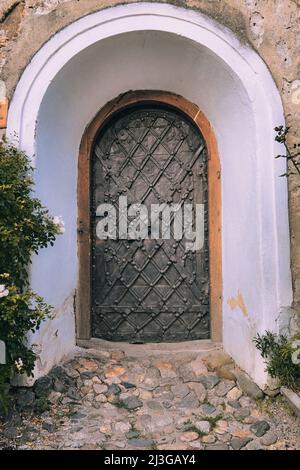 Diagonal verzierte Planke und Vorhängeschloss an der mittelalterlichen Metalltür der befestigten Kirche in Cincsor, Rumänien Stockfoto