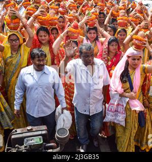 Neu Delhi, Indien April 03 2022 - Frauen mit Kalash am Kopf während des Jagannath-Tempels Mangal Kalash Yatra tragen indische Hindu-Anhänger irdische Töpfe Conta Stockfoto