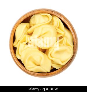 Rohe Tortelloni-Pasta in einer Holzschüssel. Ringförmige gefüllte italienische Knödel mit der gleichen Form wie Tortellini, aber größer. Stockfoto