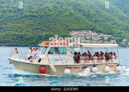 PERAST, MONTENEGRO - 20. JULI 2021: Boot mit Touristen im Meer vor der Kulisse der Berge Stockfoto